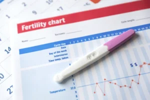 Negative pregnancy test resting on a fertility chart representing ivf failure singapore.