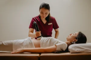TCM therapist performing a abdominal massage therapy session following a low amh test singapore.
