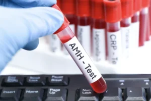 Gloved hand holding an AMH blood test vial used to assess ovarian reserve and estimate how many IVF cycles does it take to get pregnant.