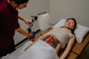 Woman undergoing TCM heat therapy on her abdomen to optimize fertility when considering how many IVF cycles does it take to get pregnant.