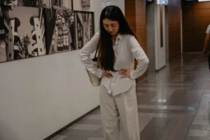 Woman holding her lower abdomen in discomfort from a menstrual disorder singapore.
